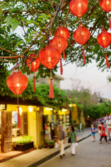 Scenic evening view of green tree decorated with red lanterns