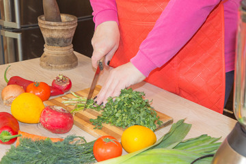 human hands cooking vegetables salad in kitchen on the table. Healthy meal concept