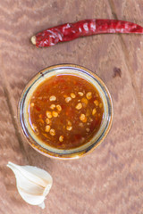 Chili sauce in bowl on wooden table