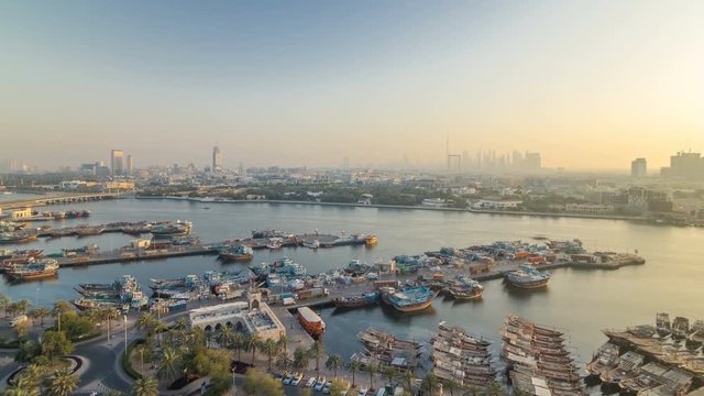 Dubai creek landscape timelapse with boats and ship in port and modern buildings in the background during sunset