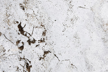Cracked grungy white stone wall with imperfections and holes as  simple texture background