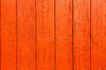 Old grungy and weathered red orange painted wooden wall plank simple texture background.
