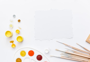 Top view Palette of watercolor paints, brushes on white background. Flat lay
