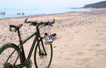 Fototapeta premium Bike on the beach. Sneakers hanging on the bike. Sea and bike.