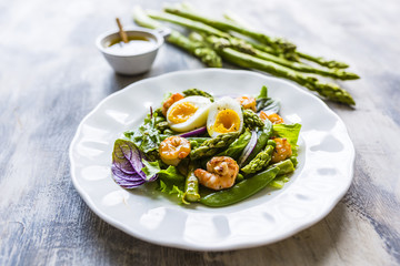 Salad with shrimps and green asparagus with peas.