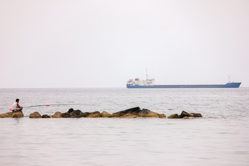 Fisherman fishing with spinning rods, reels at lake water.