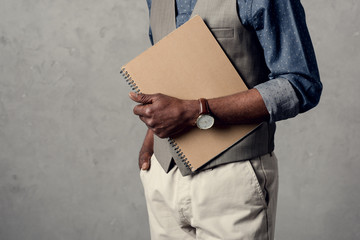 cropped view of african american businessman holding planner