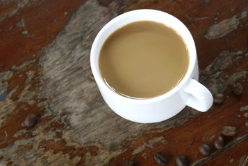 cup of coffee and beans on wood table