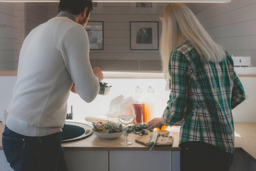 Young Cucasian couple or family cooking together at their outdoor house