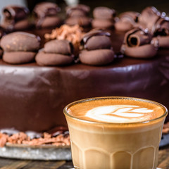 Icing on top of a chocolate mud cake with a cup of coffee