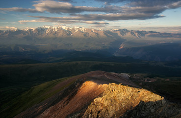 Dramatic sunset above the highland mountain valley with ranges of snow peaks rocks Altai Siberia Russia