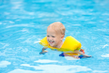 Fototapeta na wymiar Baby in swimming pool. Kids swim.