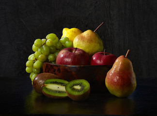 fruit in a wooden bowl on a dark background