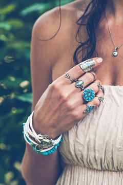 closeup of young woman hand with  lot of boho style jewrly, rings and bracelets outdoor