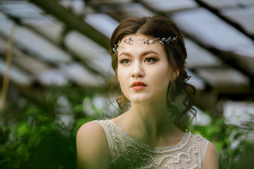 Beautiful young woman makes a walk in the greenhouse around indoor flowers and plants