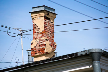 Old brick chimney on the roof of the building