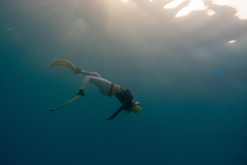 A young women free diving in the pacific ocean