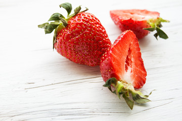Berries of strawberries on a light wooden background. Copy space.
