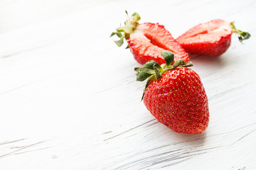 Berries of strawberries on a light wooden background. Copy space.