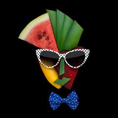 Tasty art  /Creative concept photo of cubist style female face in sunglasses made of fruits and vegetables, on black background.