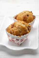 Banana pecan muffin on white wooden background