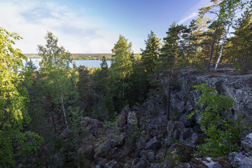 Lake, lush forest, rocky hill and cliff viewed from the Pirunvuori (