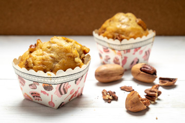 Banana pecan muffin on white wooden background