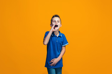 Isolated on orange young casual teen boy shouting at studio
