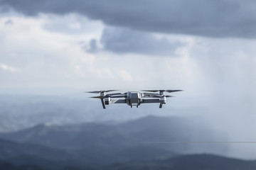 Fototapeta na wymiar Drone quadrocopter with high resolution digital camera flying on the cloudy thunder sky