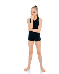 Girl gymnast in a black T-shirt and shorts prepare for the exerc