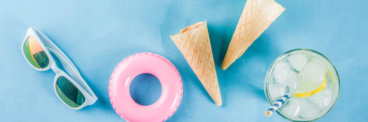Summer holidays vacation concept background, hat, sunglasses, cooling drink (lemonade, mojito) with ice, ice cream cones, Lifebuoy blue background copy space flatlay above banner