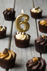 Number 6 celebration birthday cupcakes on a wooden background