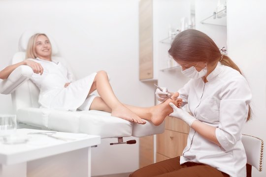 Podiatrist Doctor Cleaning Foot From Callus.