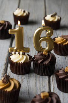 Number 16 celebration birthday cupcakes on a wooden background
