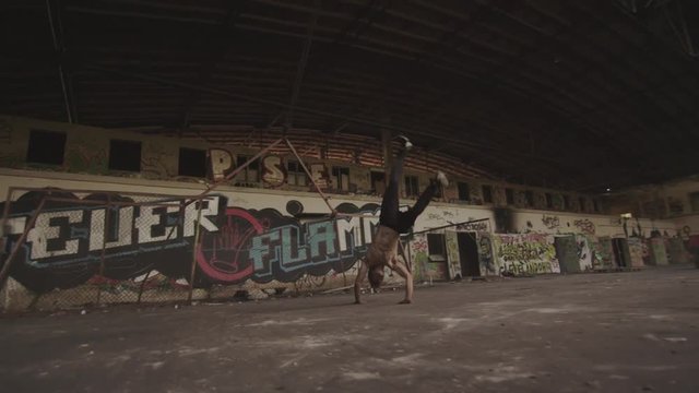 Freerunner doing tumbling combo in an abonedoned Factory