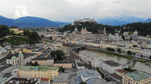 Aerial panoramic view of cityscape of Salzburg city, Salzach River, Salzburg Cathedral, old historic Fortress Hohensalzburg and Alps mountains in backgroung - landscape of Austria from above, Europe