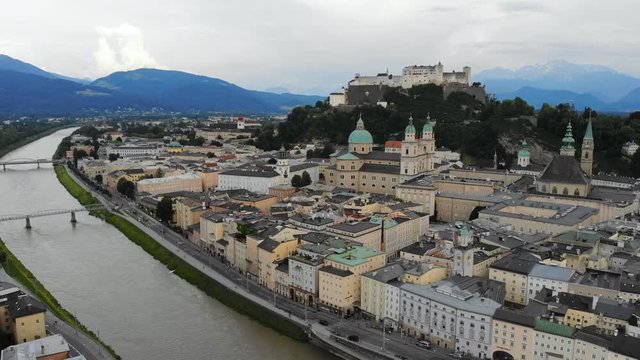 Aerial panoramic view of cityscape of Salzburg city, Salzach River, Salzburg Cathedral, old historic Fortress Hohensalzburg and Alps mountains in backgroung - landscape of Austria from above, Europe