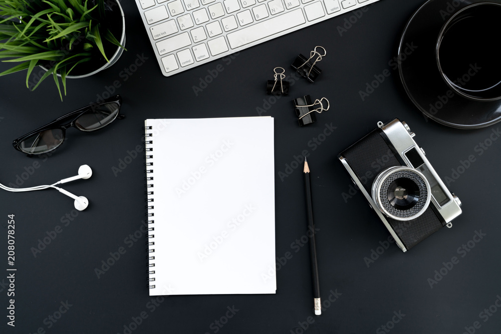 Poster flat lay of top view modern black desk work table with computer laptop,retro film camera and station