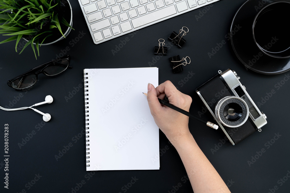 Poster flat lay of top view business woman lecture in notebook on modern black desk work table with compute