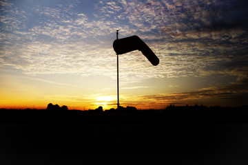 Silhouette of a small airport windsock against the early morning sunrise in Indiana, USA