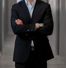 Cropped head Man standing in a smart suit with folded arms