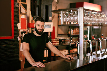 Fototapeta na wymiar Bartender In Beer Pub. Portrait Of Man At Bar Counter