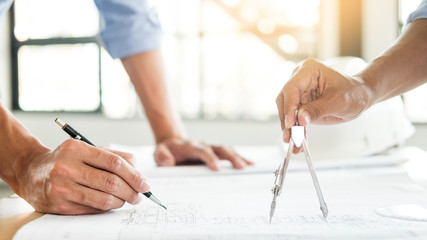 Close-up Of Person's engineer Hand Drawing Plan On Blue Print with architect equipment, Architects discussing at the table, team work and work flow construction concept