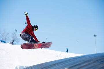 Picture of young sportive man jumping with snowboard