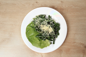 appetizer of asparagus and lettuce on a white plate on wooden ba