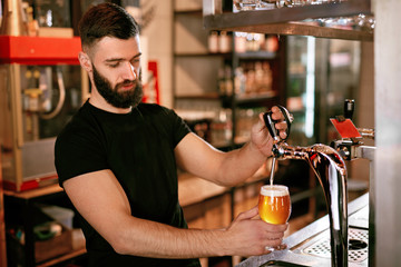 Bartender Working At Bar Pub Pouring Beer In Glass