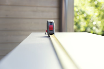 Furniture assembly. Construction measuring tape on chipboard furniture part. Making of kitchen...