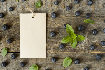 Blueberries and mint leaves on rustic wooden background Copy space for text