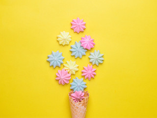 Ice cream cone with pink,blue, yellow meringues on a  colorful  background. Sweet summer concept. Top view. Flat lay.Pastel colors.Dessert