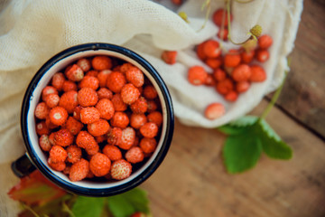 Wild strawberry basket on wooden background